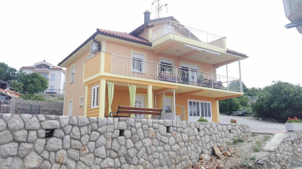 a yellow house behind a stone wall at Apartment Gebic Ivan in Crikvenica