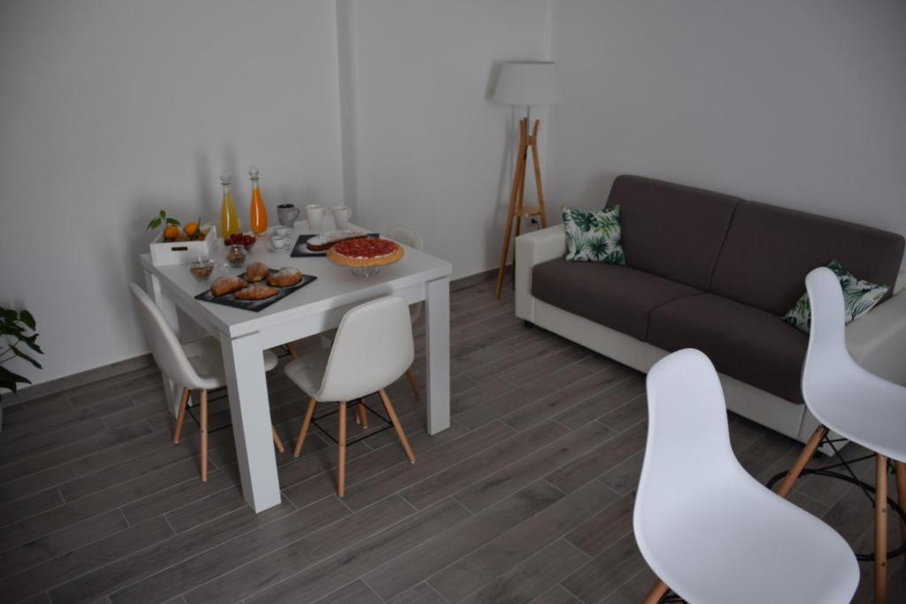 - un salon avec une table, des chaises et un canapé dans l'établissement Dimora Santa Caterina, à Conversano