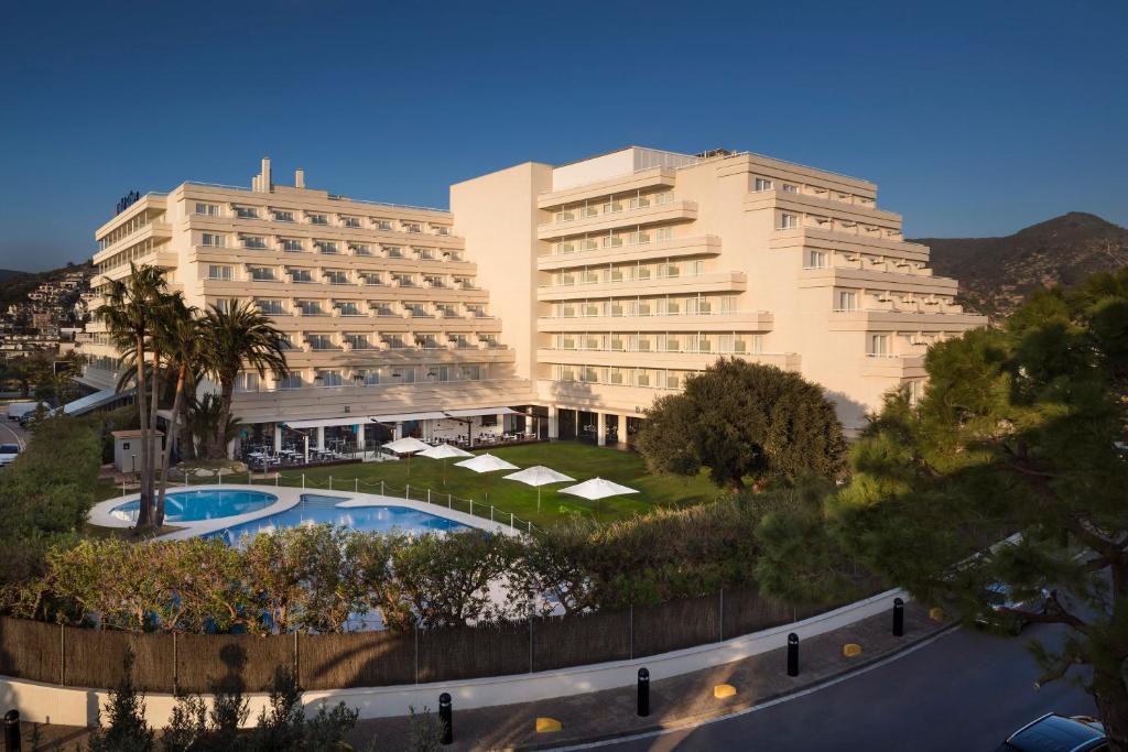 a view of a hotel with a pool and two buildings at Melia Sitges in Sitges