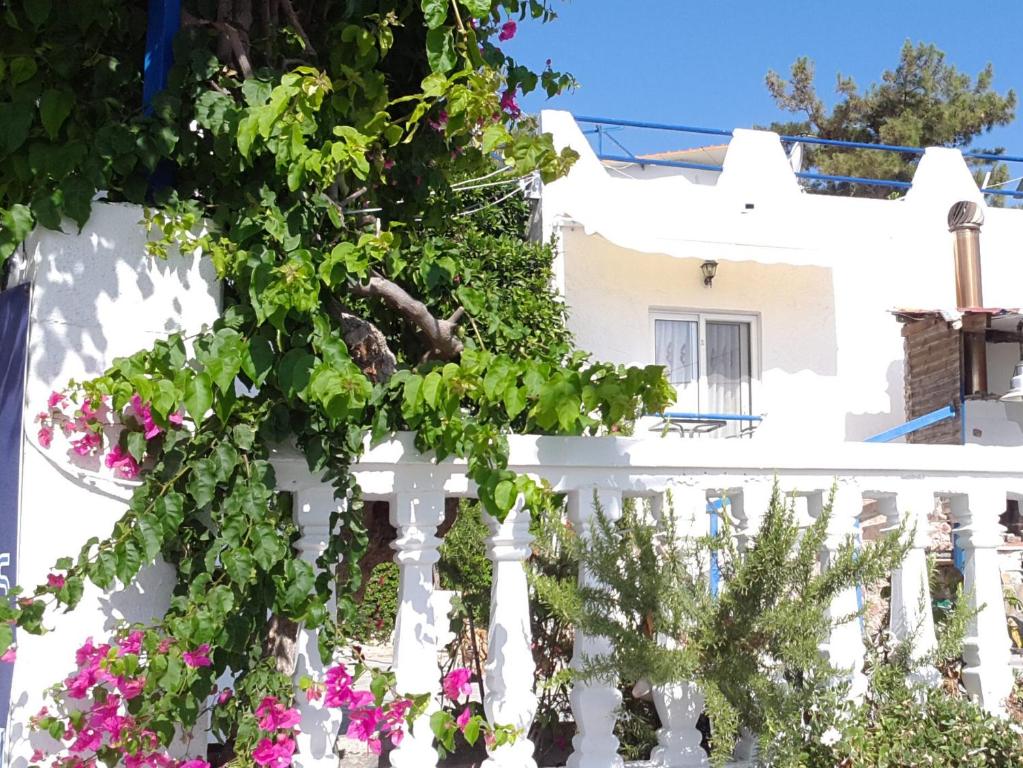 a white fence with flowers in front of a house at Paradis Studios in Archangelos