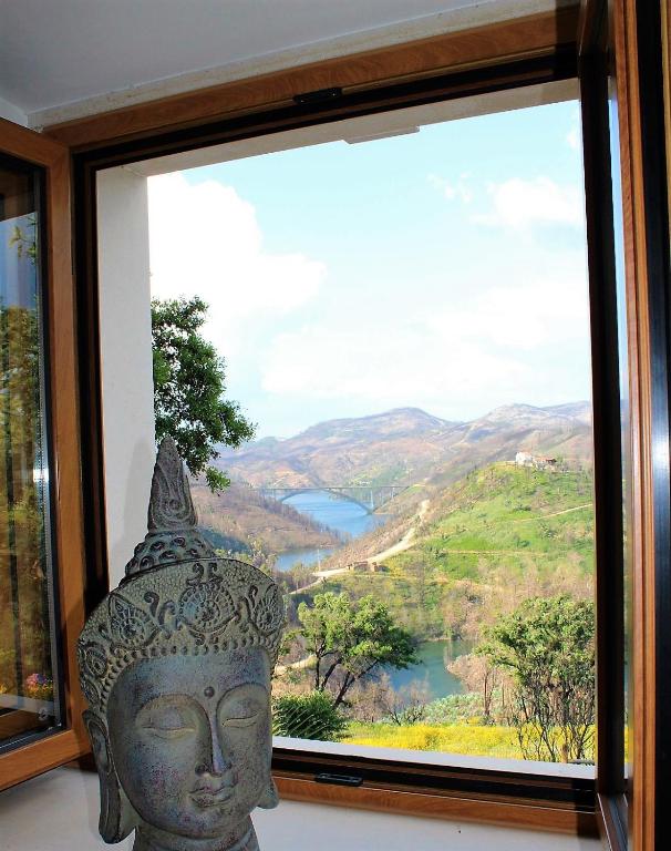 a large statue in front of a window with a view at Oak Cottage in Ferreira do Zêzere