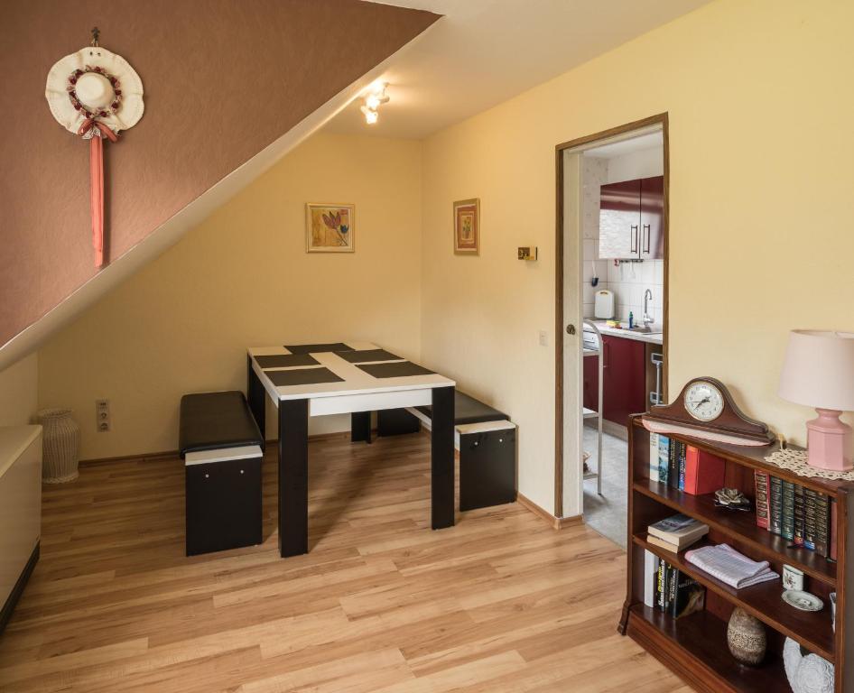 ein Esszimmer mit einem Tisch und einer Treppe in der Unterkunft Gästezimmer Strauß in Kottenheim