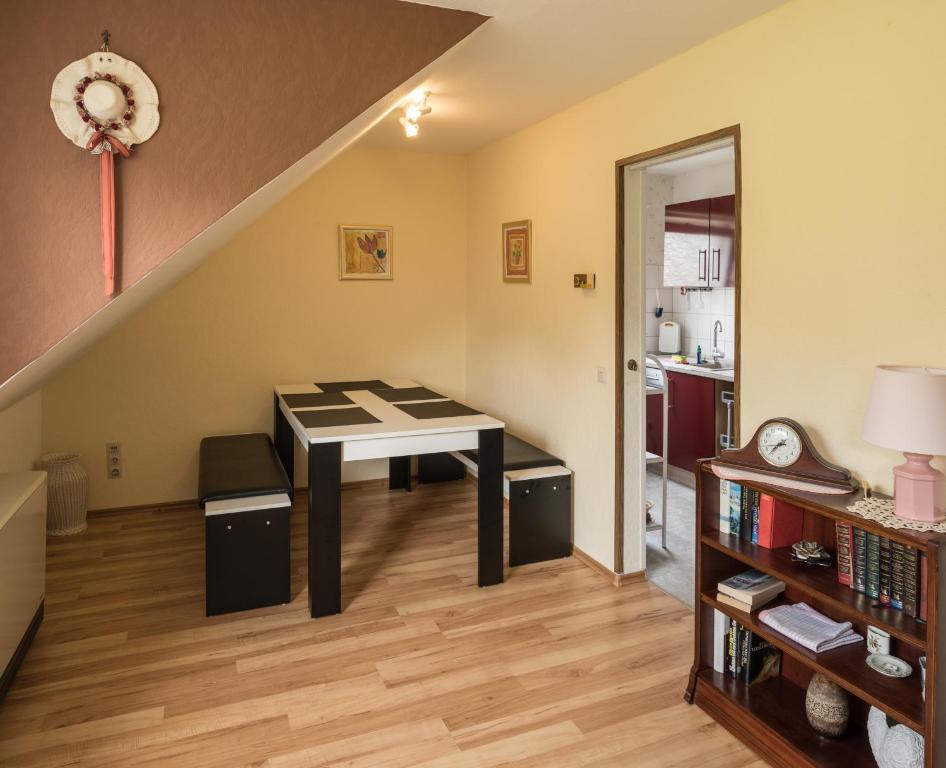 a dining room with a table and a staircase at Gästezimmer Strauß in Kottenheim