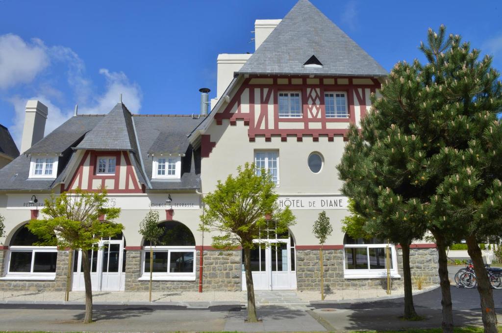 un grand bâtiment avec un panneau à l'avant dans l'établissement Hotel De Diane, aux Sables-dʼOr-les-Pins