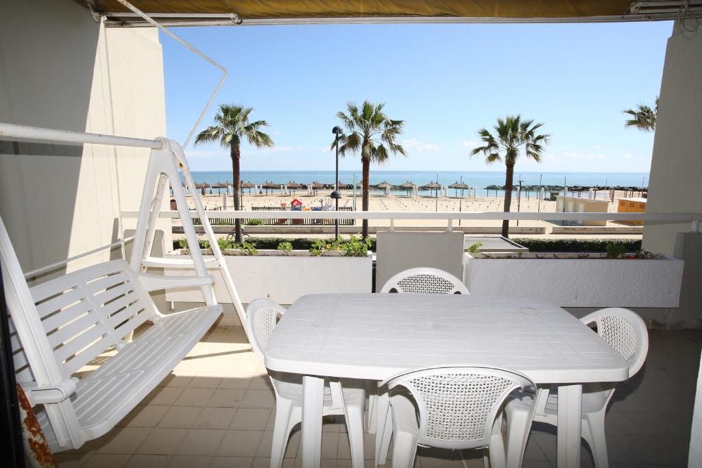 un tavolo bianco e sedie su un balcone con vista sulla spiaggia di Residence Le Palme a Montesilvano
