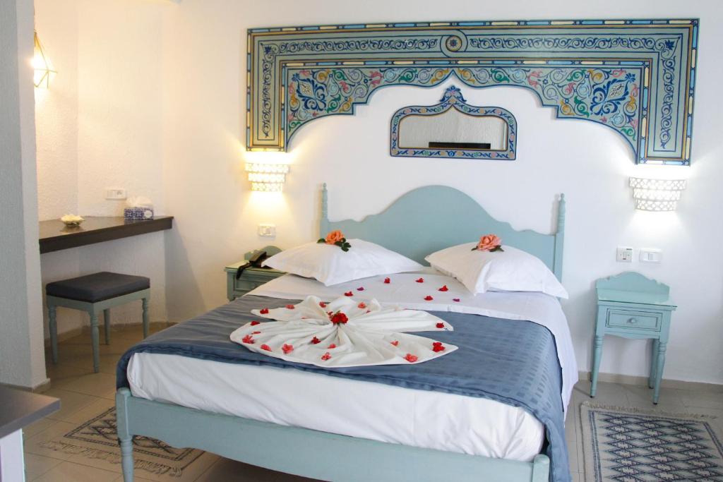 a bedroom with a blue and white bed with flowers on it at Hotel Khella in Hammamet