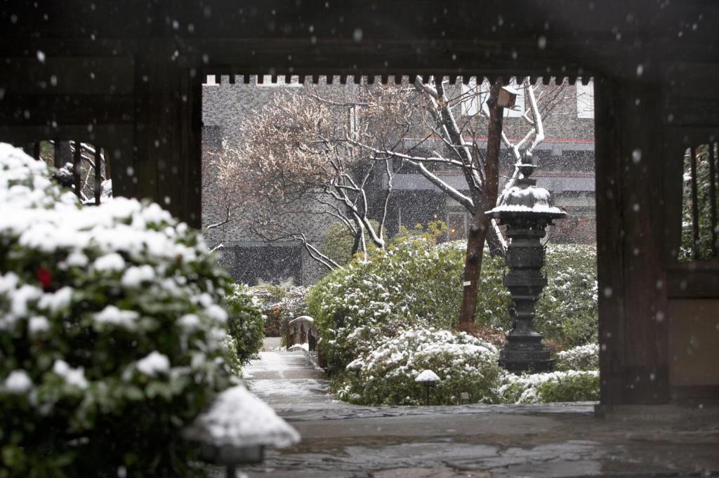 a snow covered garden with a light pole and bushes at Grand Prince Hotel Takanawa in Tokyo