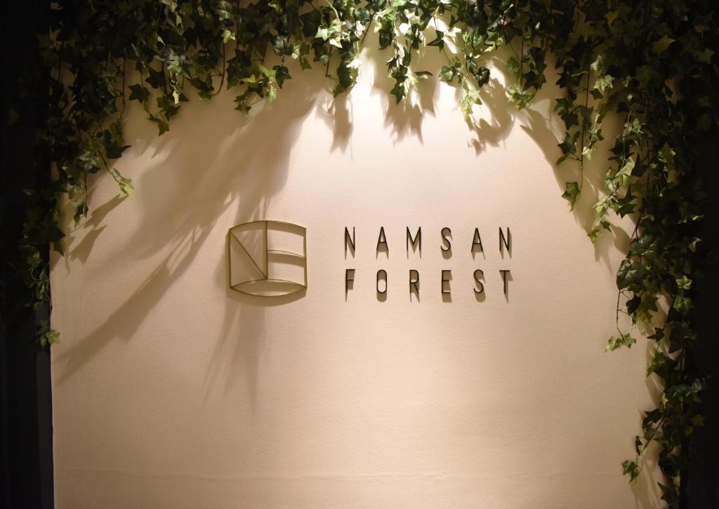 un panneau indiquant une forêt manzanienne avec du lierre dans l'établissement Namsan Forest in Myeongdong, à Séoul