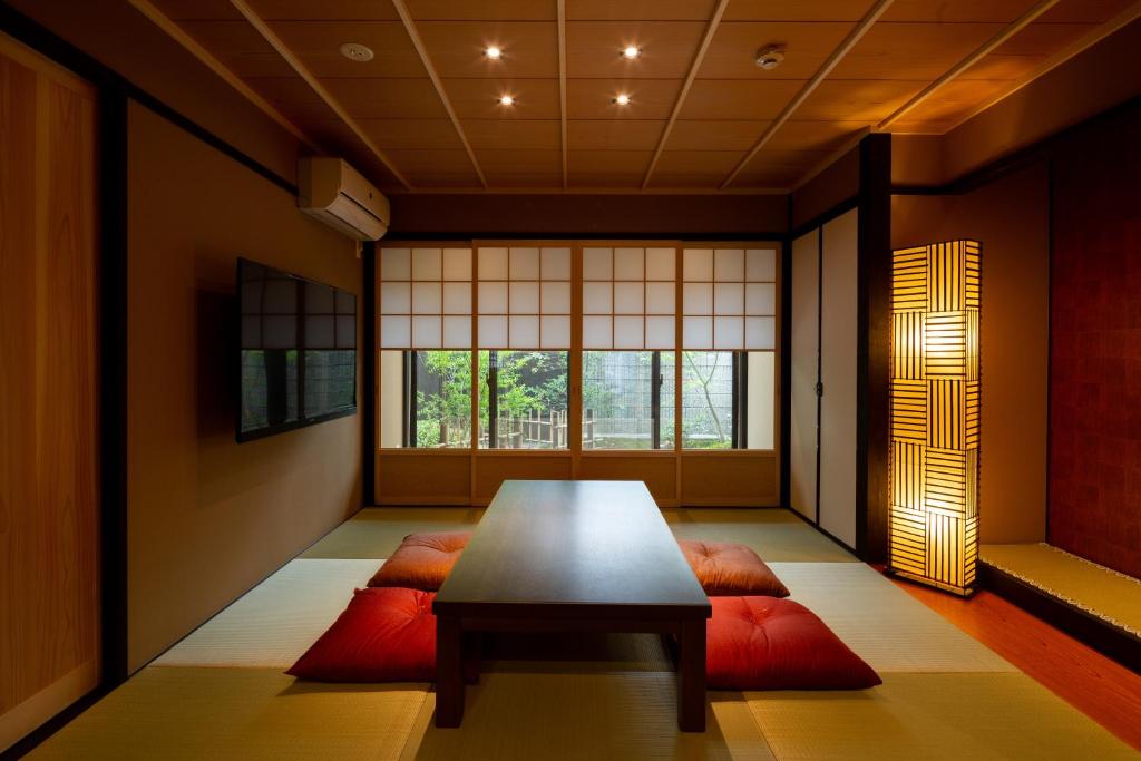 a dining room with a table and red pillows at Kanade Fushimiinaribettei in Kyoto