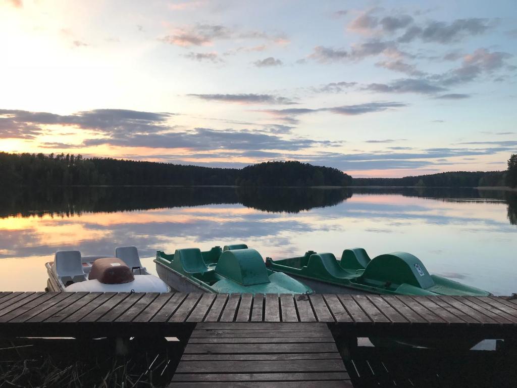 a couple of boats sitting on a dock on a lake at Ośrodek Wypoczynkowy "Na Cyplu" Spychowo in Spychowo