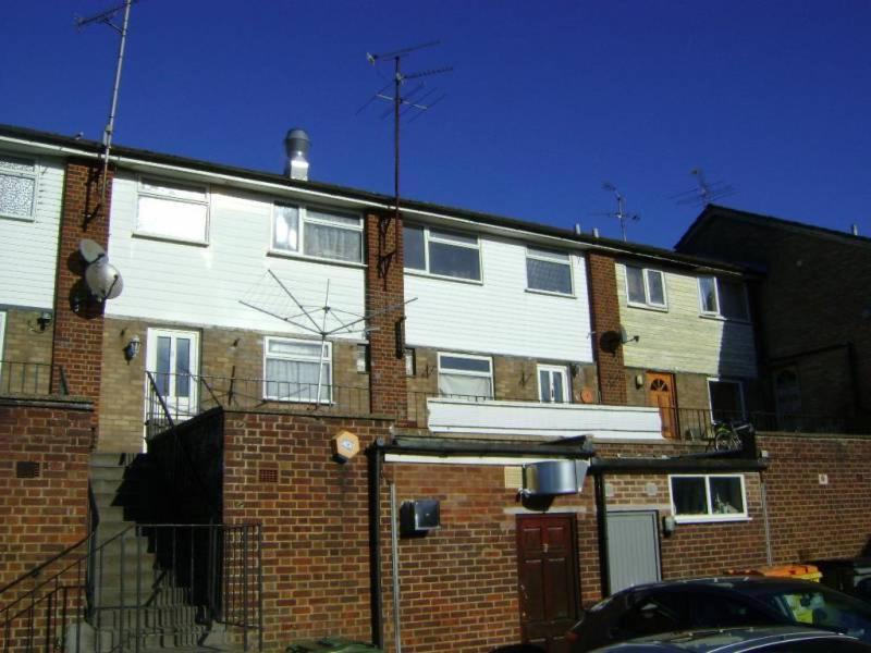 a large brick building with a fence in front of it at Elmfield Court in Bordon