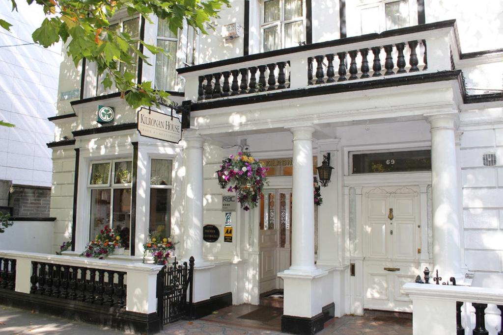 a white building with a white front door and flowers at Kilronan House in Dublin