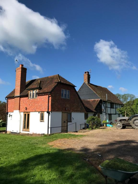 una casa con dos chimeneas en la parte superior de un patio en Hurst Hill en Dunsfold