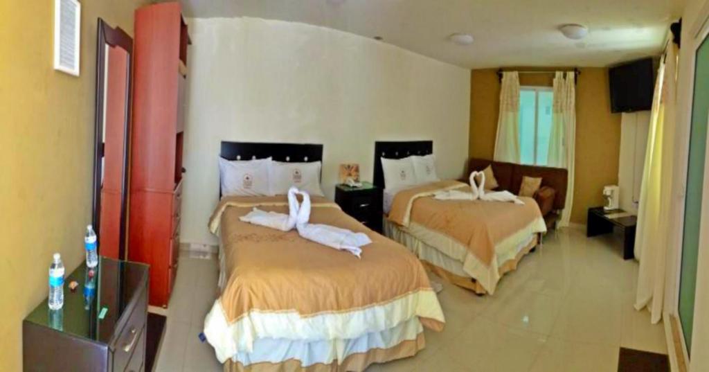 Una habitación de hotel con dos camas con cisnes. en Hotel El Refugio, en Tlaxcala de Xicohténcatl