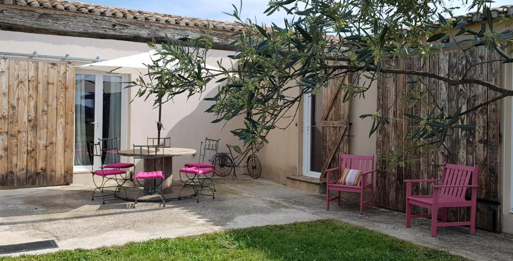 een patio met roze stoelen en een tafel bij Manade de la clapiere-Mas du Plan in Le Cailar