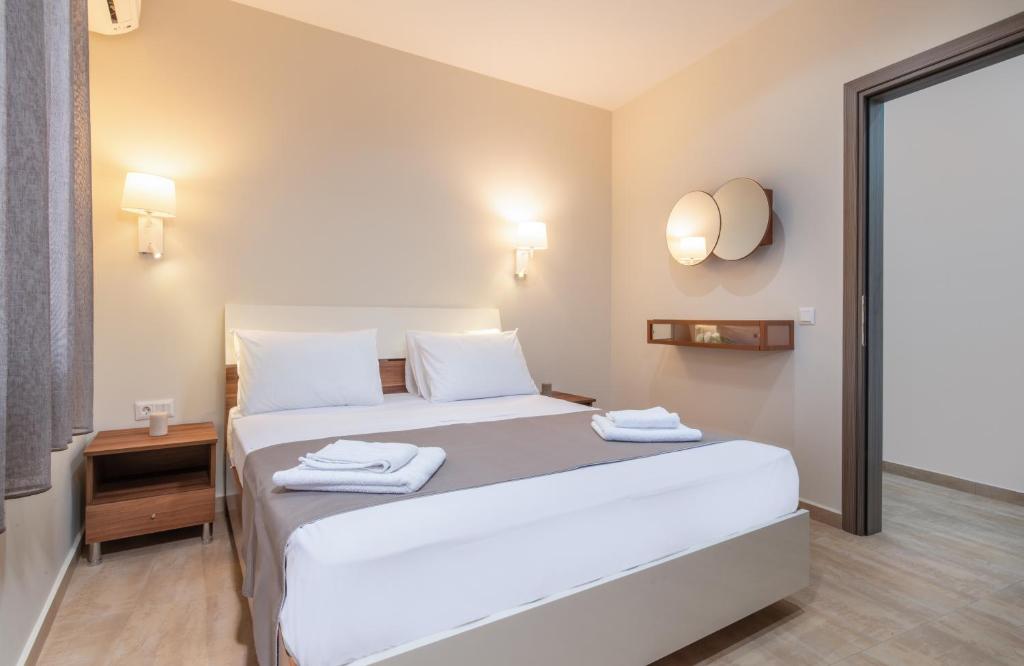 ネオス・マルマラスにあるKamis Suiteのベッドルーム1室(大きな白いベッド1台、タオル付)