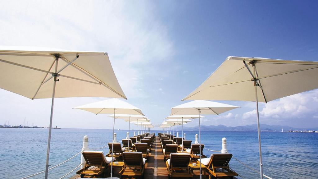 une longue rangée de chaises et de parasols sur l'eau dans l'établissement Victoria, à Cannes