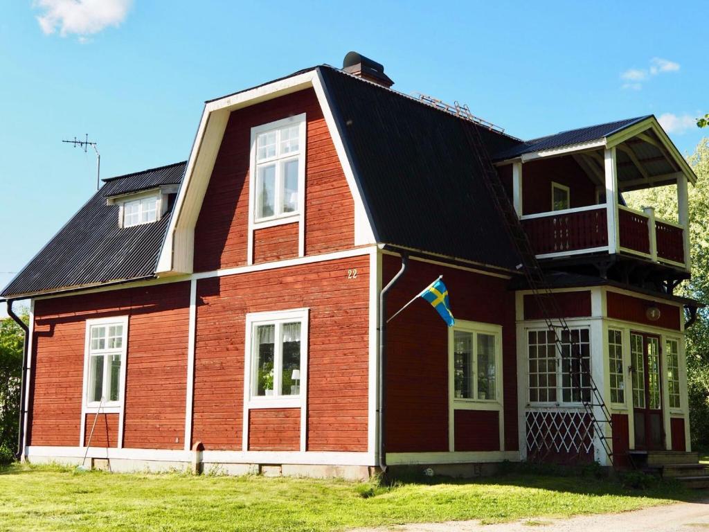 a large red house with a black roof at Orsastuguthyrning-Kyrkbyn in Orsa