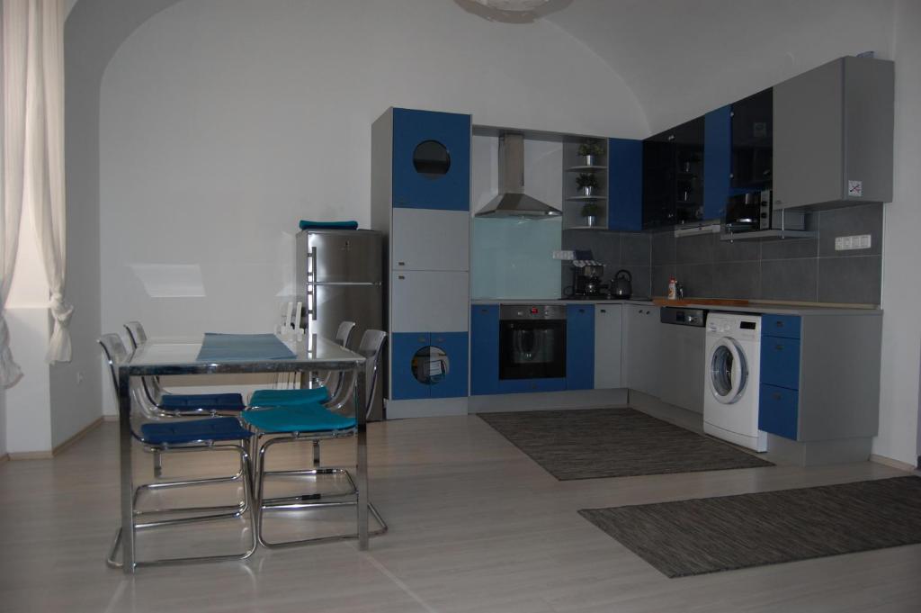 a kitchen with a table and chairs and a washing machine at Apartman a Szentlélek u. -3ban in Sopron