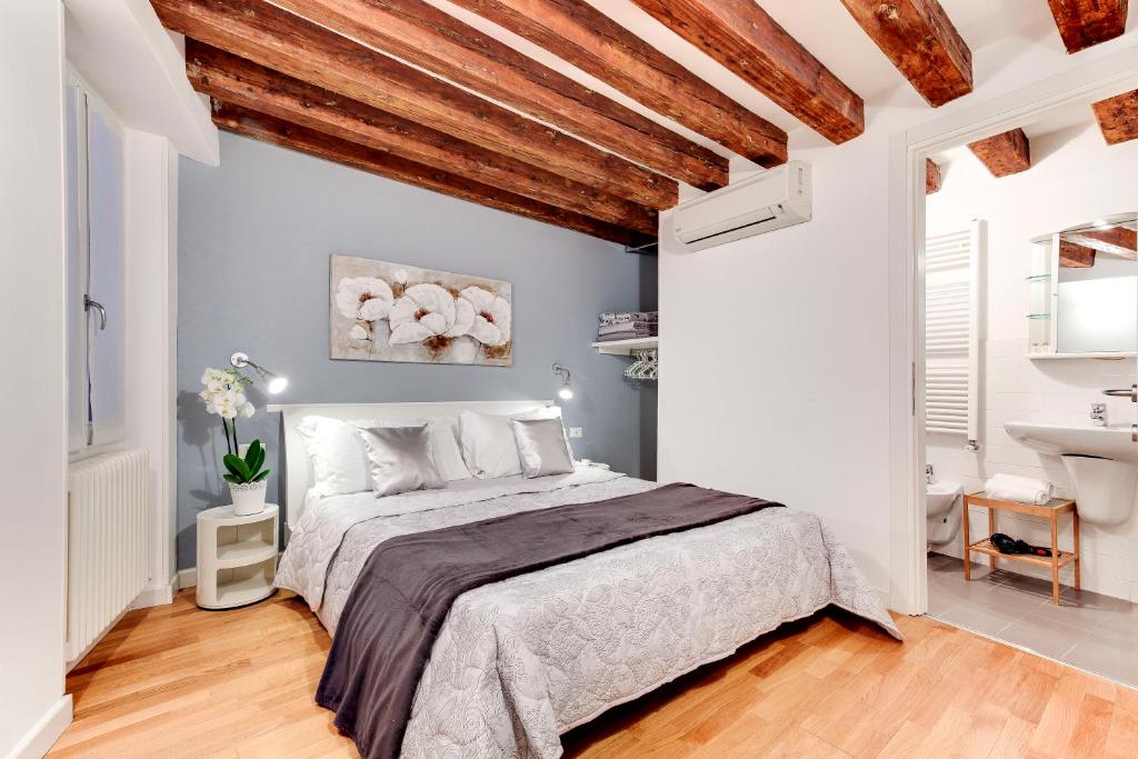 een slaapkamer met een groot bed en een badkamer bij San Marco - Campo Manin in Venetië