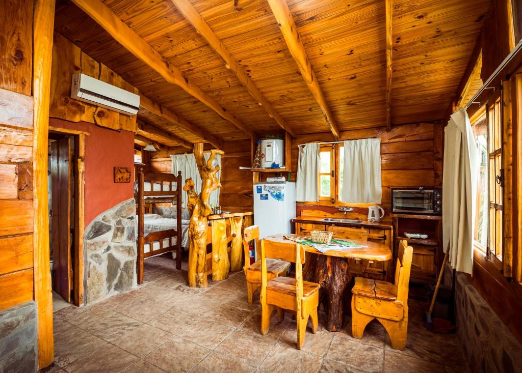 a kitchen with a table and chairs in a cabin at Complejo Flores Azules in Olta