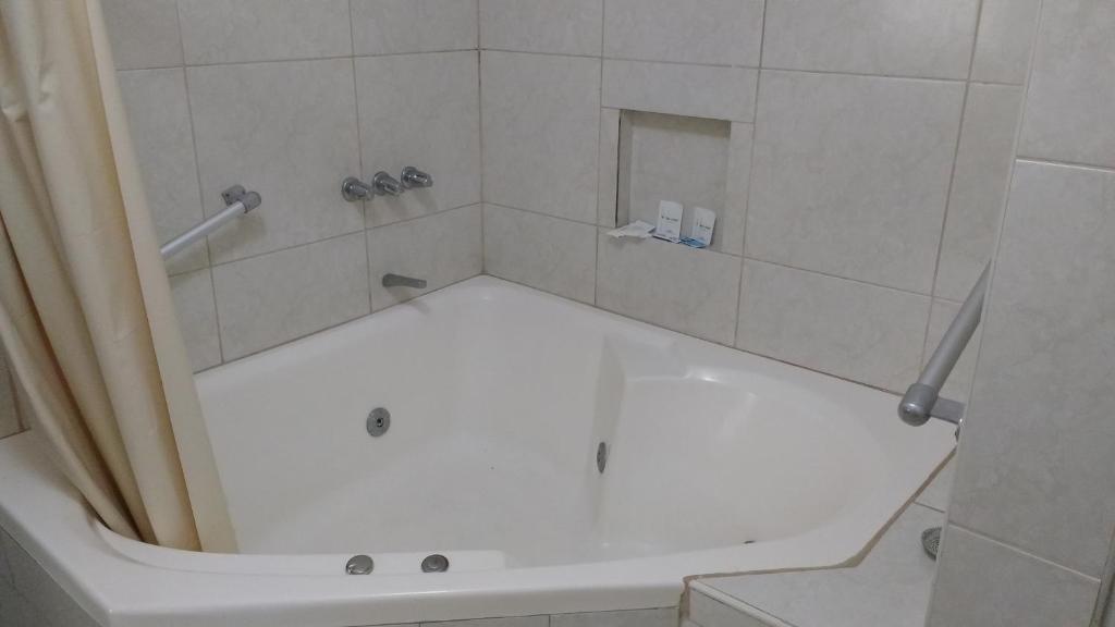 a bathroom with a shower with a white tub at Venecia Hotel Carrion in Trujillo