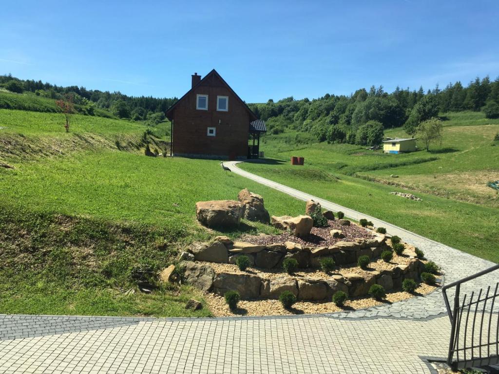 une maison au milieu d'un champ avec un jardin de rochers dans l'établissement Karpacka Chata, à Rymanów-Zdrój