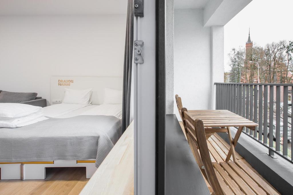 a bedroom with a bed and a table on a balcony at #draugunamai in Druskininkai