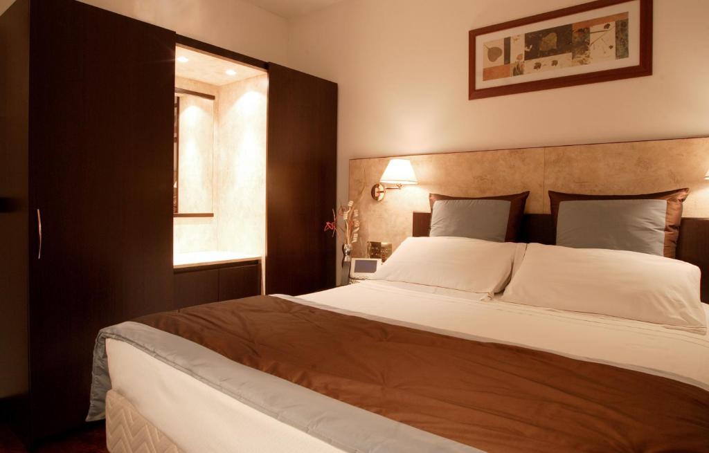 a bedroom with a large white bed with a window at Residence Le Magnolie in Forlì