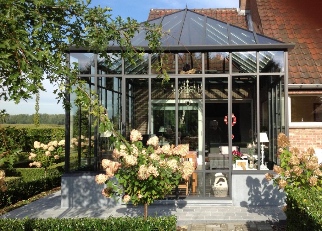 an internal view of a glass house with flowers at De Moeraseik in Zele