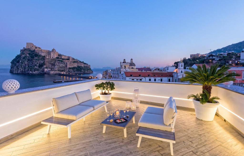 balkon z krzesłami i widokiem na ocean w obiekcie Exclusive Home Ischia w mieście Ischia