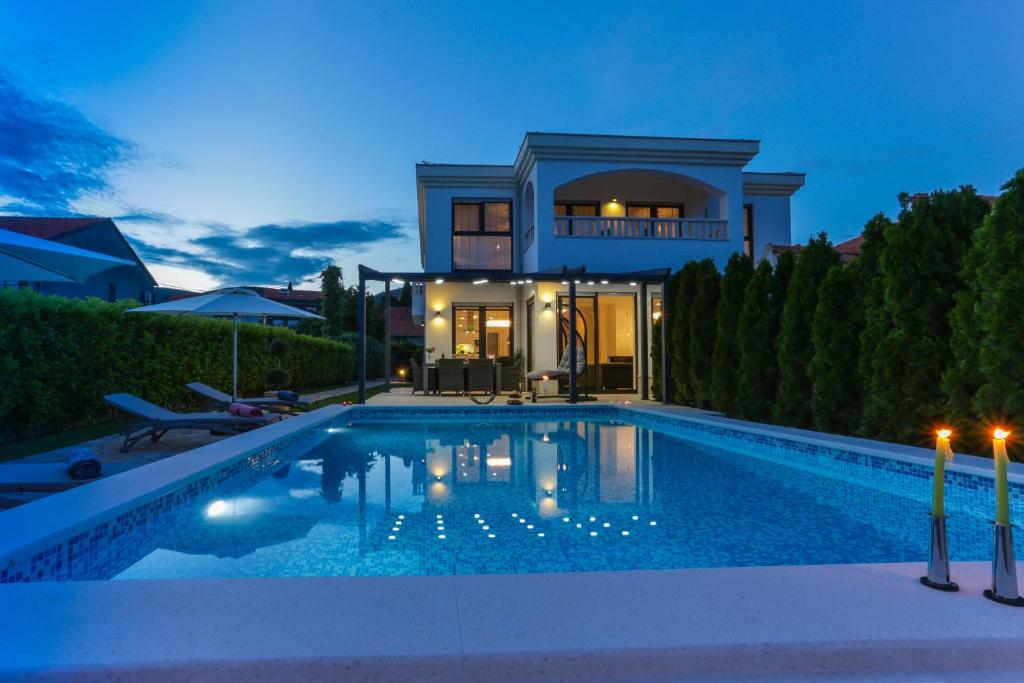 a villa with a swimming pool at night at Luxury City Villa Trogir in Trogir