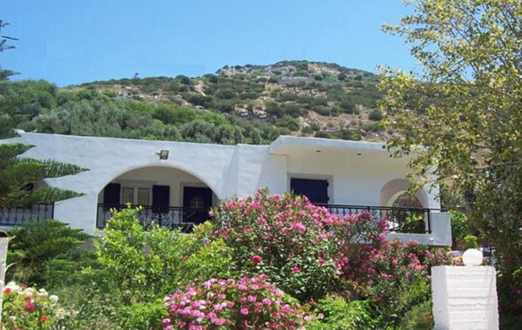 a white house with a hill in the background at Georgia Studios in Fourni Ikarias