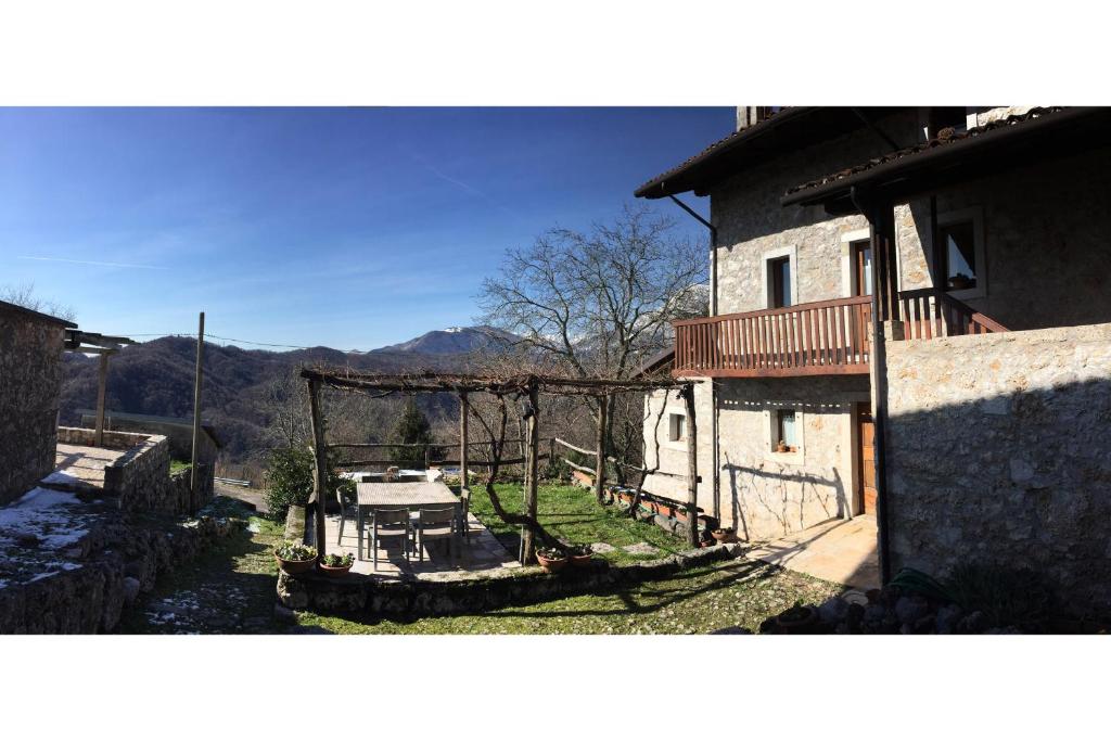 a house with a balcony and a table in the yard at A casa mia in Meduno