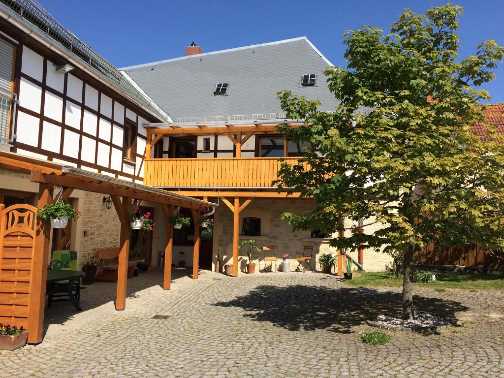 a large house with a balcony and a tree at Ferienwohnung & Pension Brückner in Auma