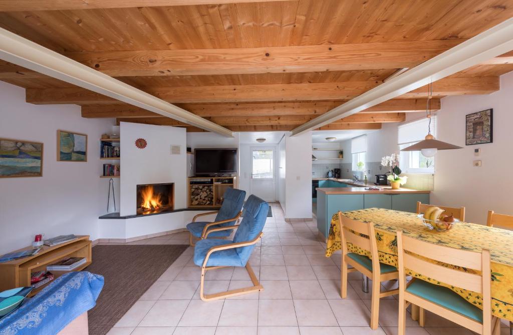eine Küche und ein Wohnzimmer mit einem Esstisch und einem Kamin in der Unterkunft Casa Blu in Frasco