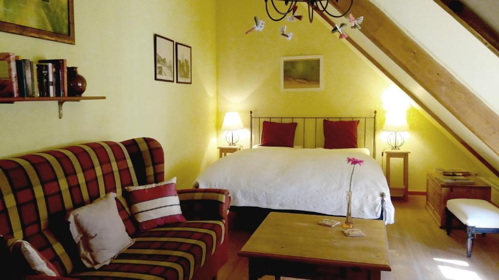 ein Schlafzimmer mit einem Bett, einem Sofa und einem Tisch in der Unterkunft Ferienwohnung im Schuhhof in Quedlinburg