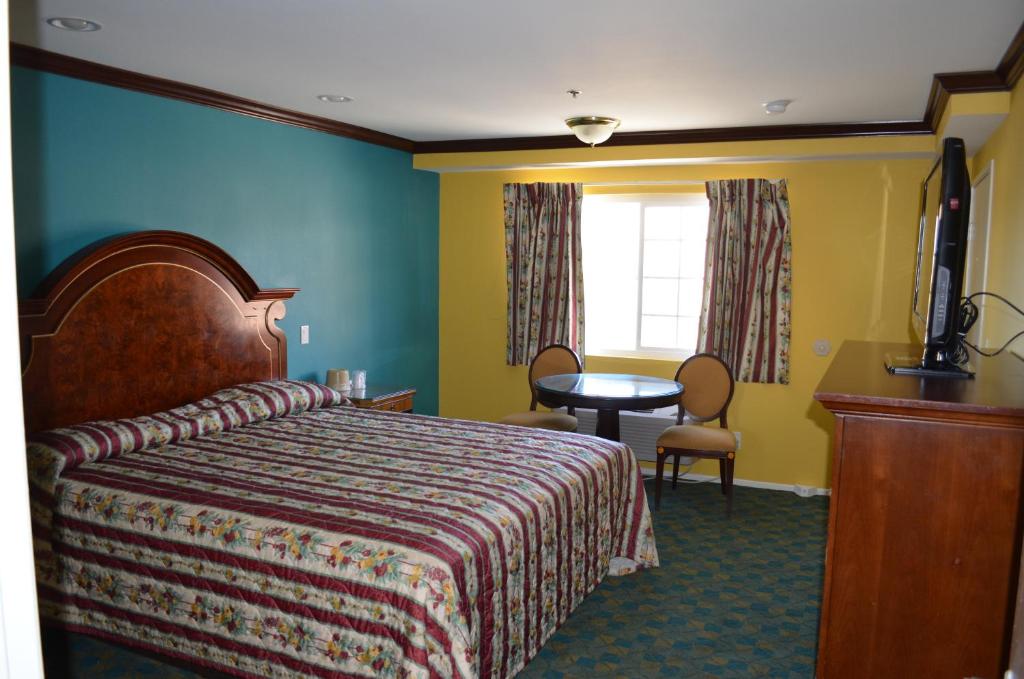 um quarto de hotel com uma cama, uma mesa e uma janela em Cloud 9 Inn LAX em Inglewood