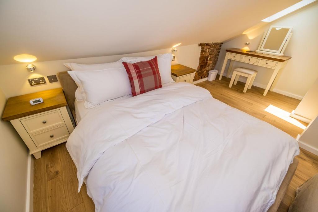 a bed with white sheets and pillows in a room at Sea View Holiday Flat - Covehurst Bay in Hastings