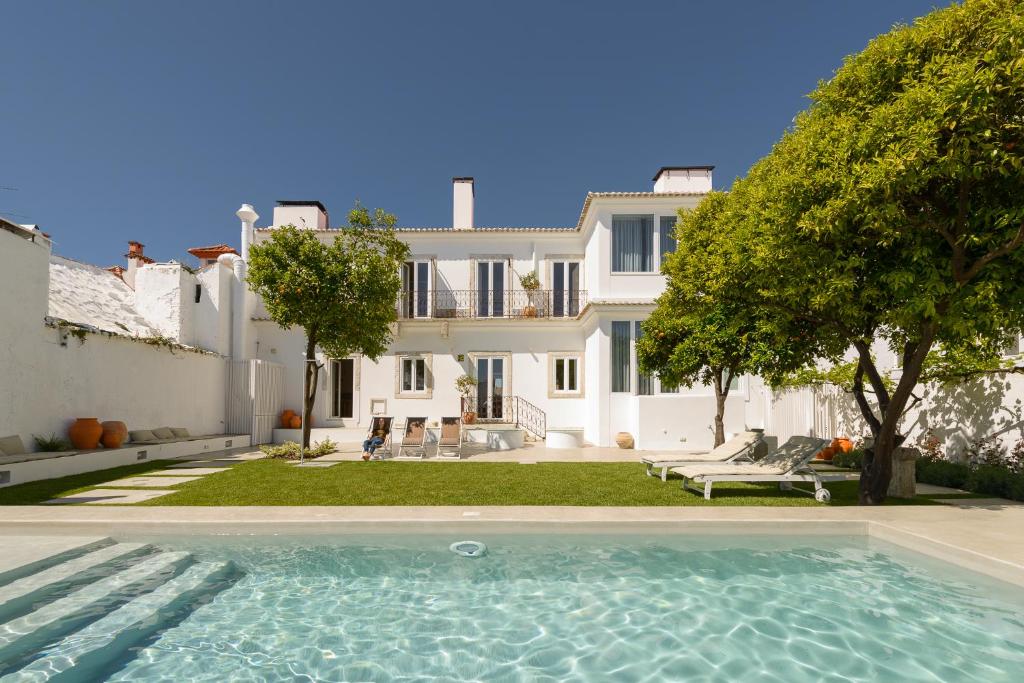 a swimming pool in front of a house at Dona Graca Lisbon Apartments in Lisbon