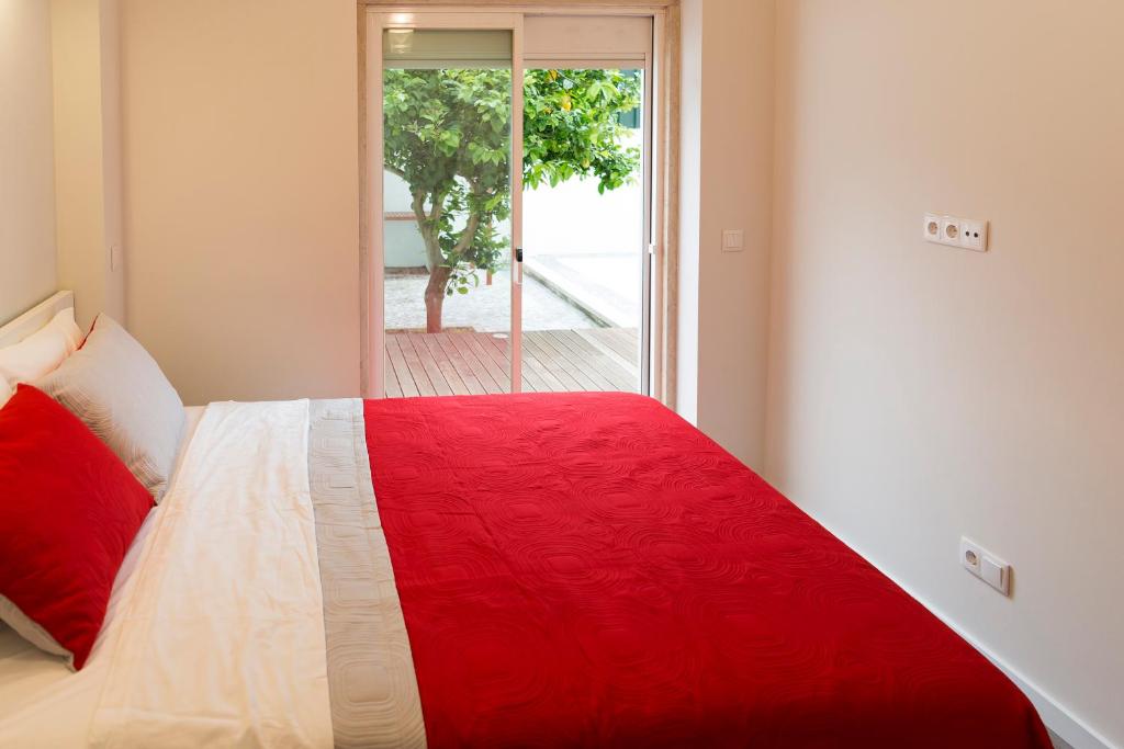 a red and white bed in a room with a window at Apartamento Ideal 3 in Lisbon