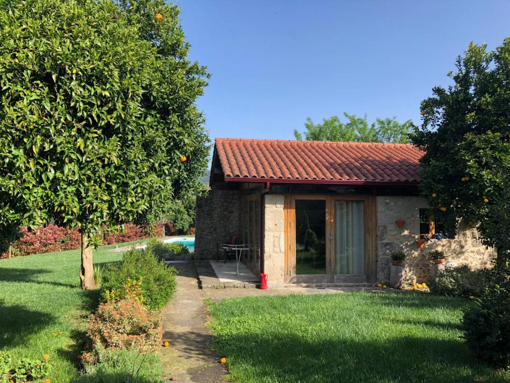 ein kleines Haus mit Garten und Baum in der Unterkunft The Olive Tree Country Home in Vila Verde