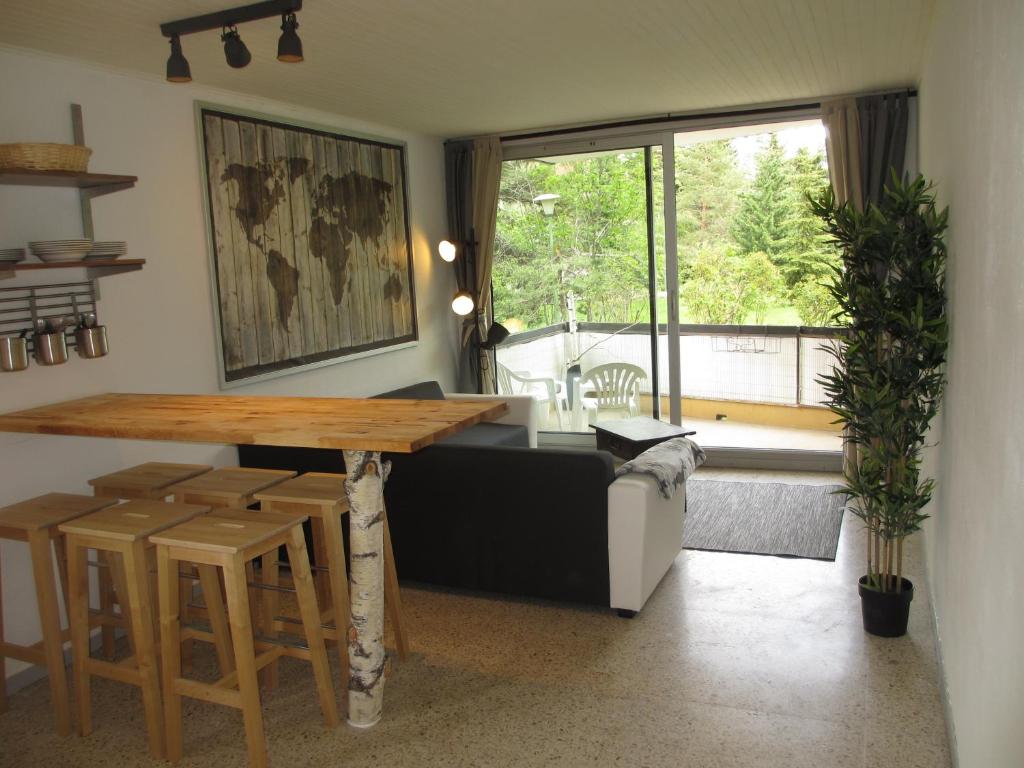 - un salon avec une table et une grande fenêtre dans l'établissement L'appart de Serre Che, à La Salle Les Alpes