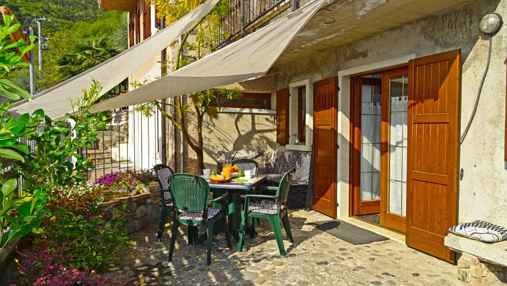 un patio con tavolo e sedie all'esterno di una casa di Casa Paola Holiday studio by Gardadomusmea a Tremosine Sul Garda