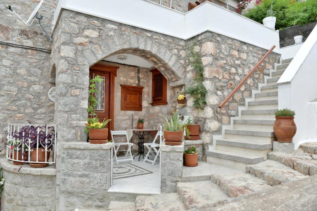a stone house with stairs and a table and chairs at Kassandra House in Hydra