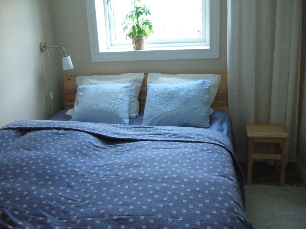 アルビカにあるHaga Gård Arvikaのベッド(青い掛け布団付)、窓が備わります。