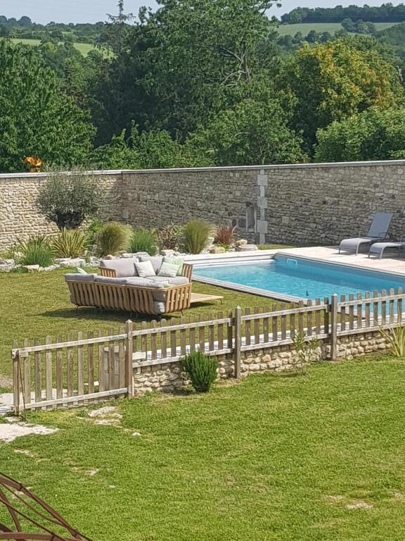 a backyard with a fence and a swimming pool at Les Hauts De Chalonne in Le Gond-Pontouvre