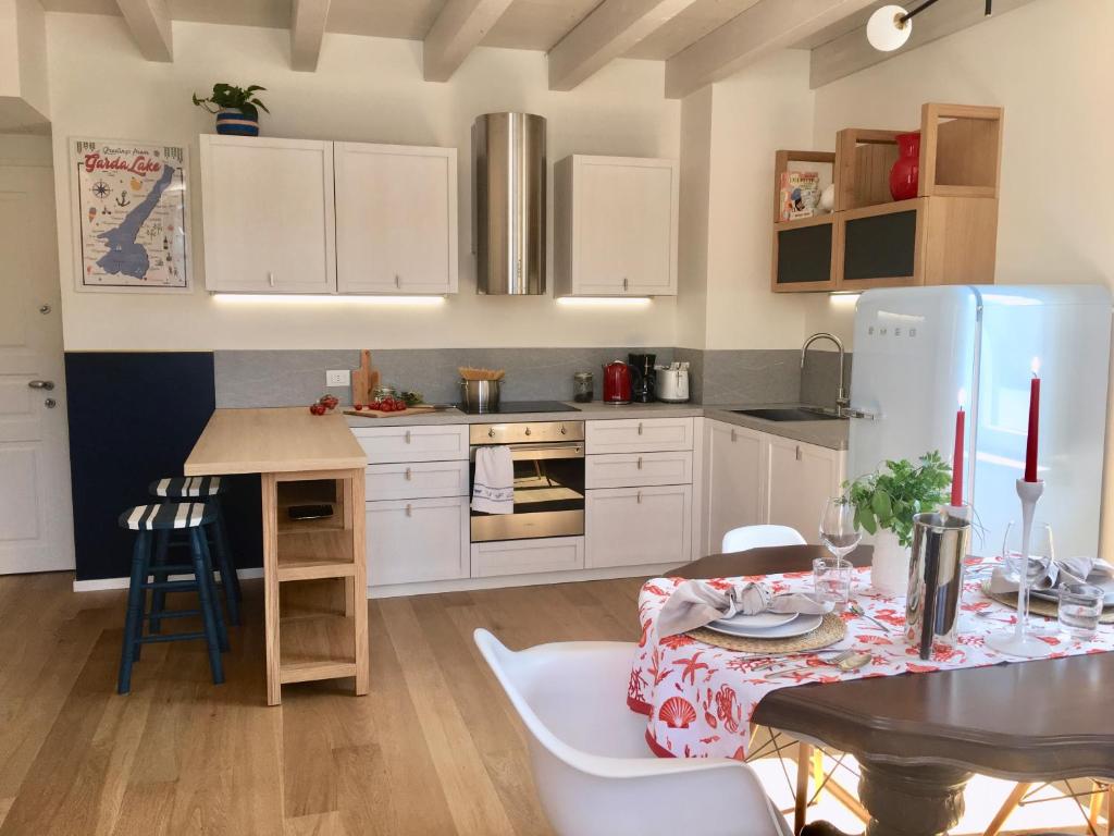 a kitchen with a table and a white refrigerator at Ponte dei Voltoni Apartment in Peschiera del Garda