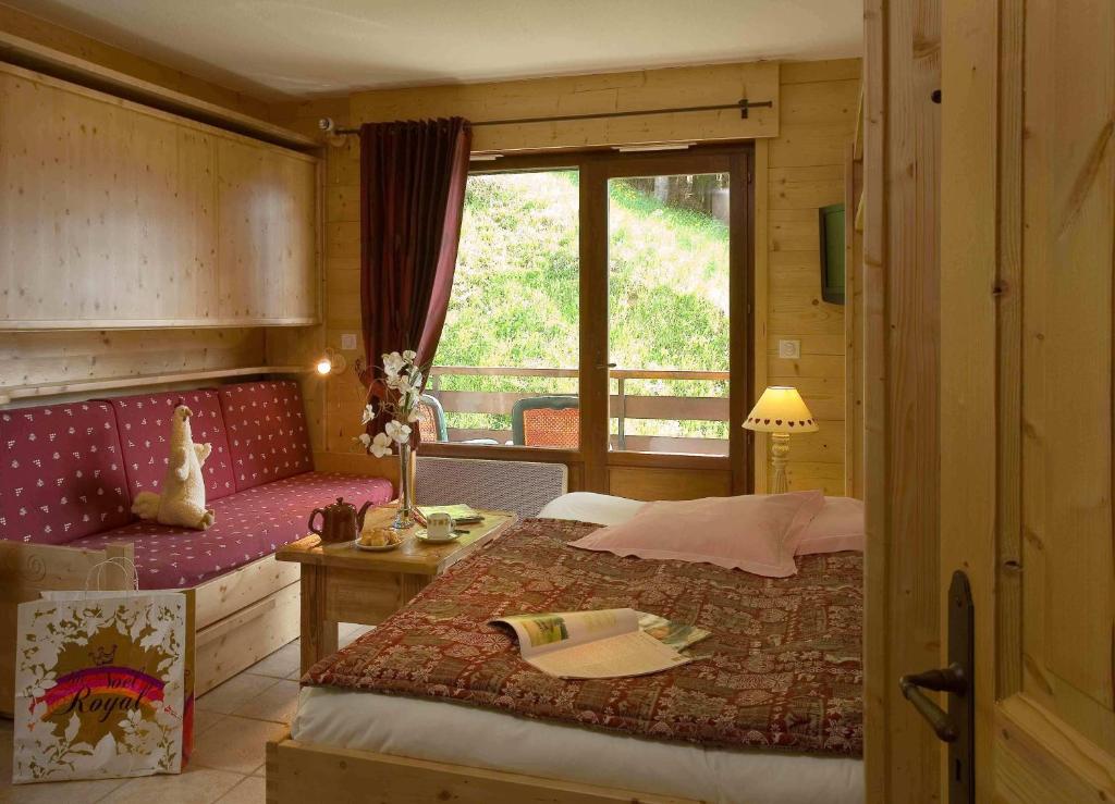 ル・グラン・ボルナンにあるRésidence Tournetteのベッドルーム1室(ベッド1台、テーブル、窓付)