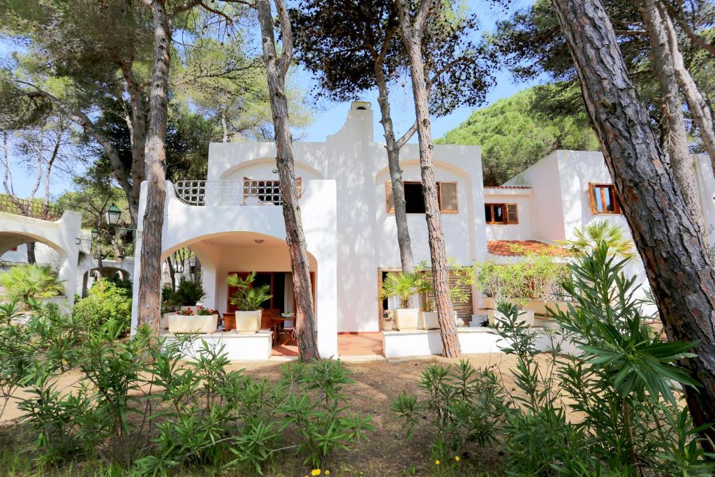 una casa blanca rodeada de árboles en Ville Campo Verde by TerraSalento, en San Cataldo